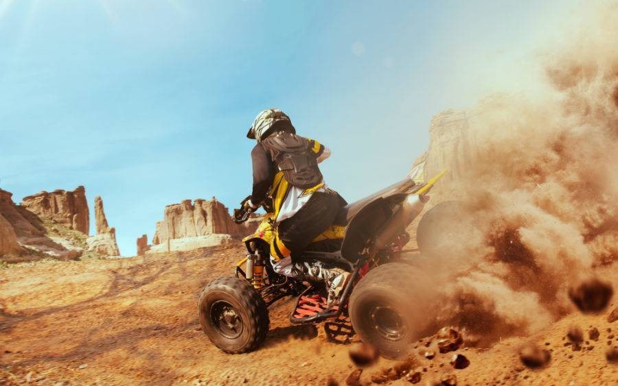 person riding ATV kicking up dust