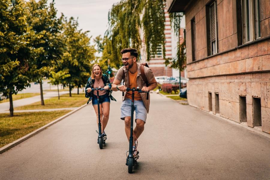 best types of rental businesses feat, two people on scooters in a city