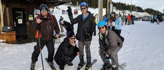 Checkfront employees pose together in ski gear at ski lodge
