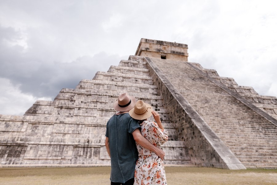 couple wearing sun hats looking at pyramids