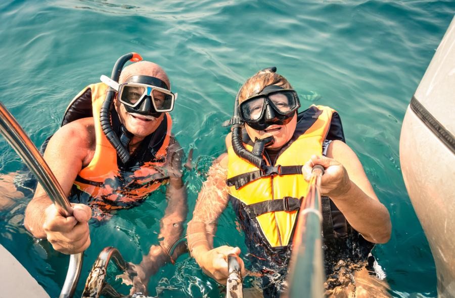 Senior traveler couple taking a selfie while snorkelling
