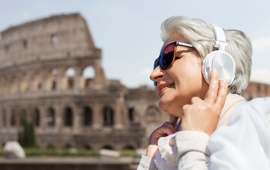 older woman listening to headphones in Rome