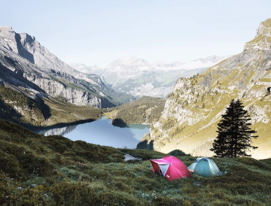 two tents in the mountains with a lake view