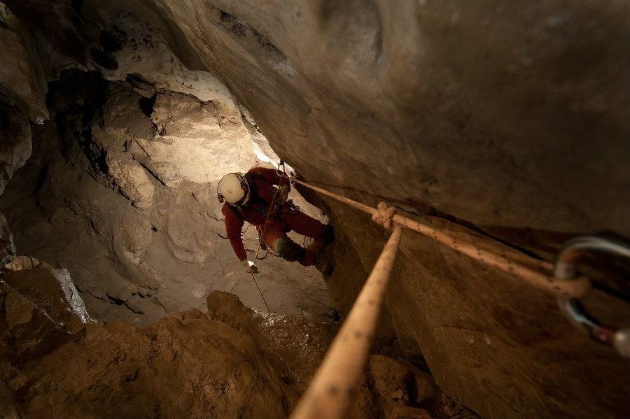 Guest rapelling while exploring cave with Canmore Cave Tours.