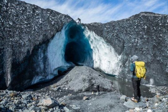 Tour operator scaling an ice cave