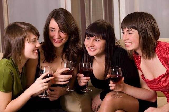 Group of girls huddling in together drinking wine on wine tasting tour