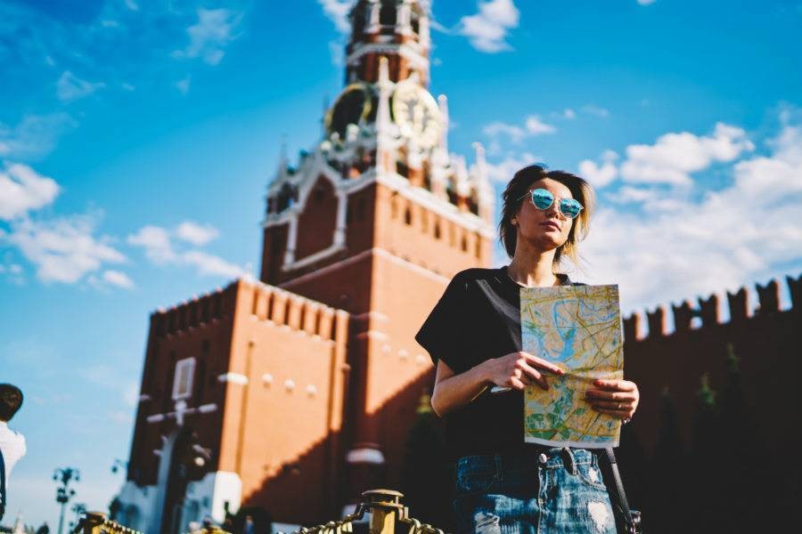 Woman holding map in front of historic building