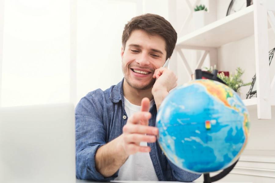 Guy on the phone spinning a globe