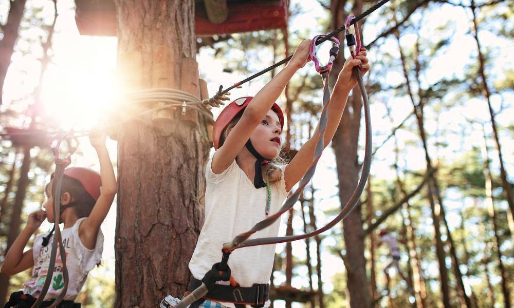A child on a ropes course in the trees