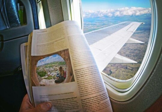 Reading a magazine on an aeroplane