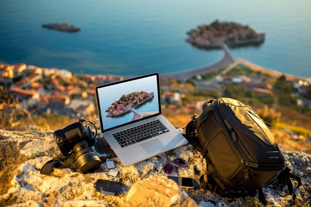 A laptop and camera on a mountain top