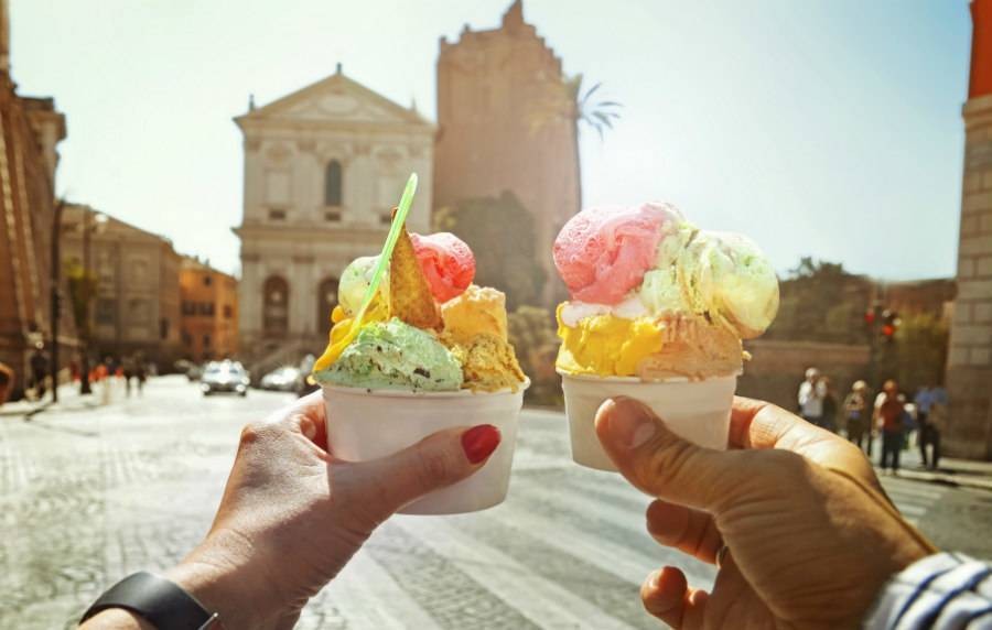 two hands holding ice cream while on tour