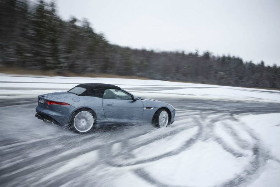 Silver Jaguar car drifting on frozen lake