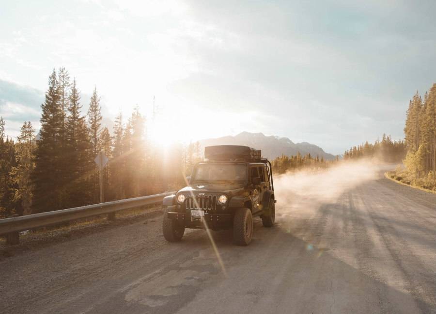 Hastings Overland Jeep rental driving down mountainous dirt road during sunset. 