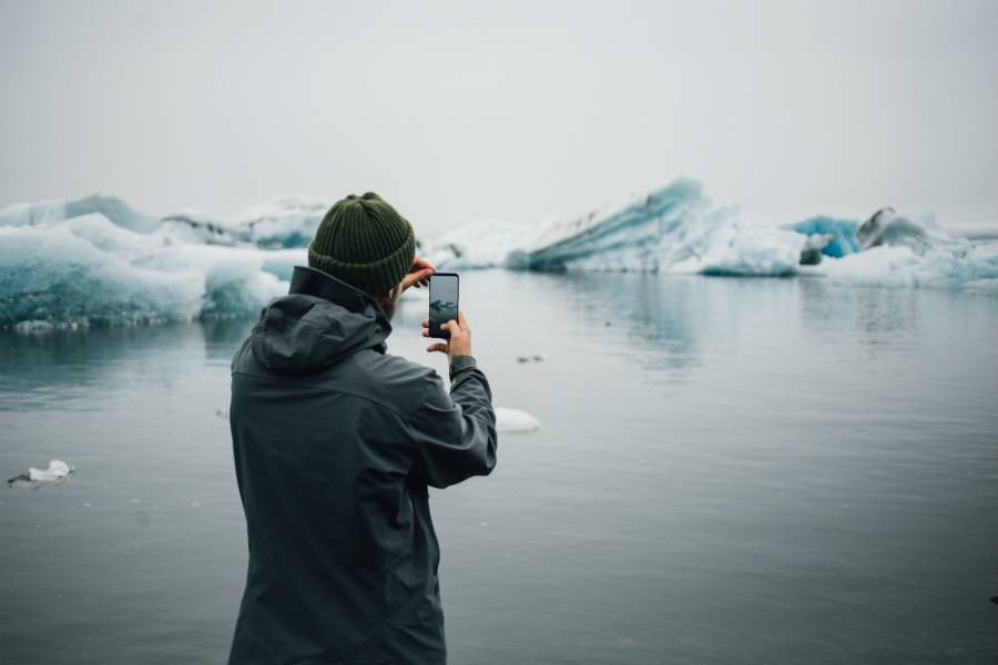 Latest digital marketing trend of traveler using smartphone on tour in Antarctica