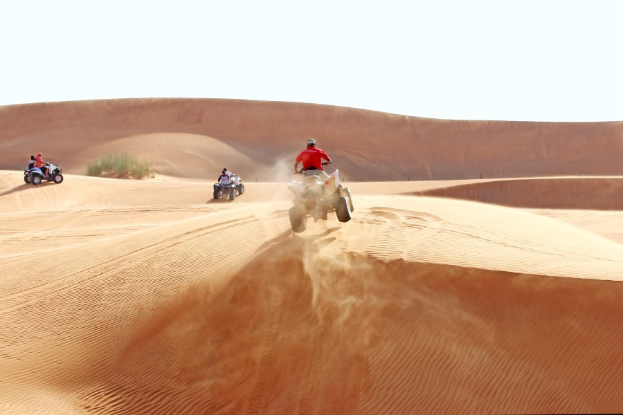 atv rider on sand dune with a rider in front