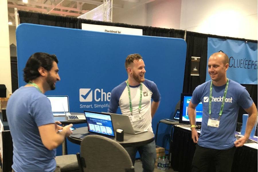 Checkfront team standing at booth at escape room conference.