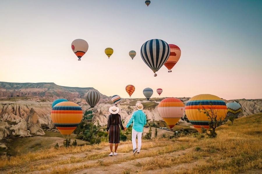 Couple watching hot air balloons in turkey at sunrise