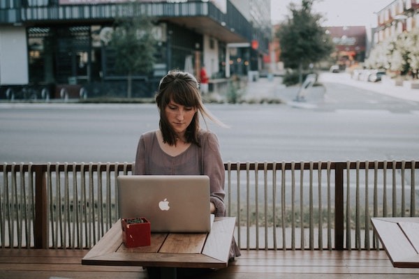 Woman sitting at outdoor cafe with a laptop