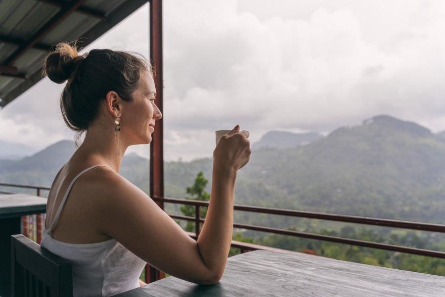 A female guest enjoying a cup of coffee overlooking a cloud-forest