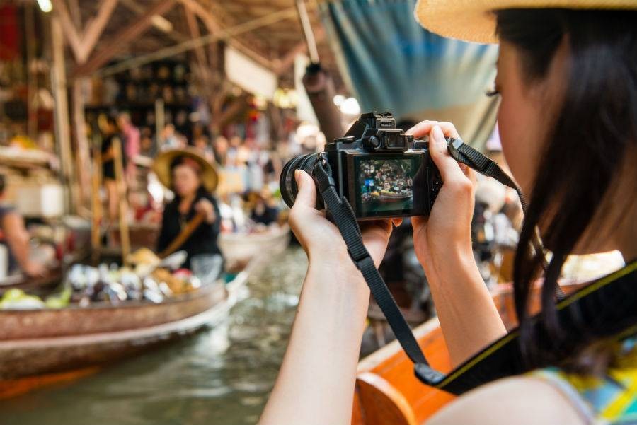 Tour guide taking YouTube video of local culture in Thailand.