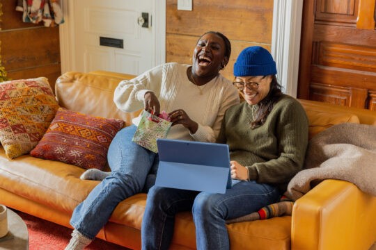 Couple sitting on the couch during the holidays shopping online for gift certificates